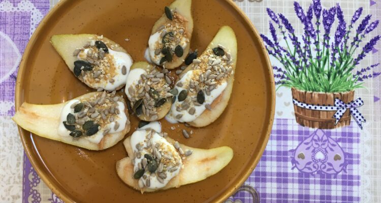 Sliced pear with yogurt and seeds on a plate