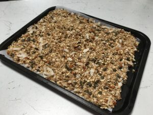 Granola fatta in casa: teglia con fiocchi di avena, cocco, semi misti, mandorle a pezzetti