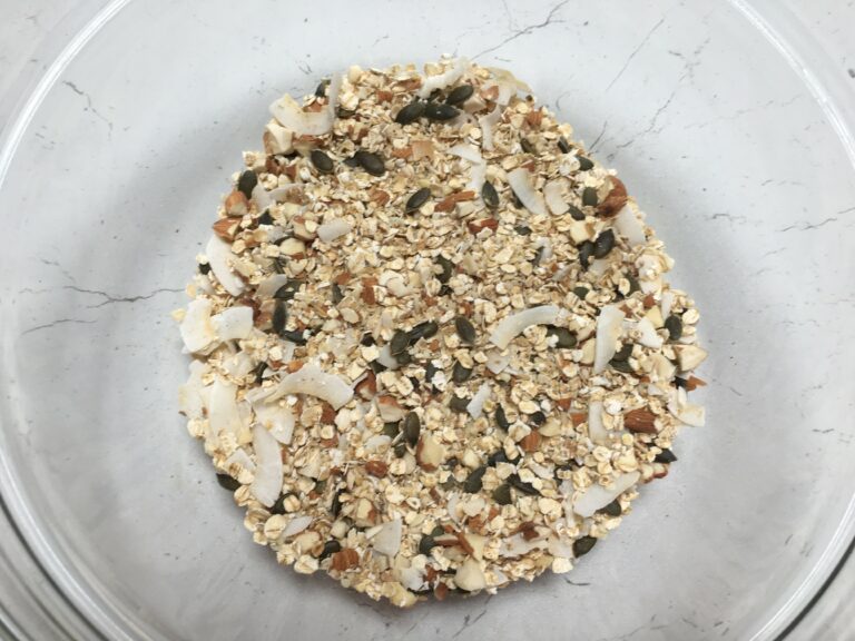 Preparazione granola fatta in casa:fiocchi di avena, cocco, semi misti e mandorle a pezzetti